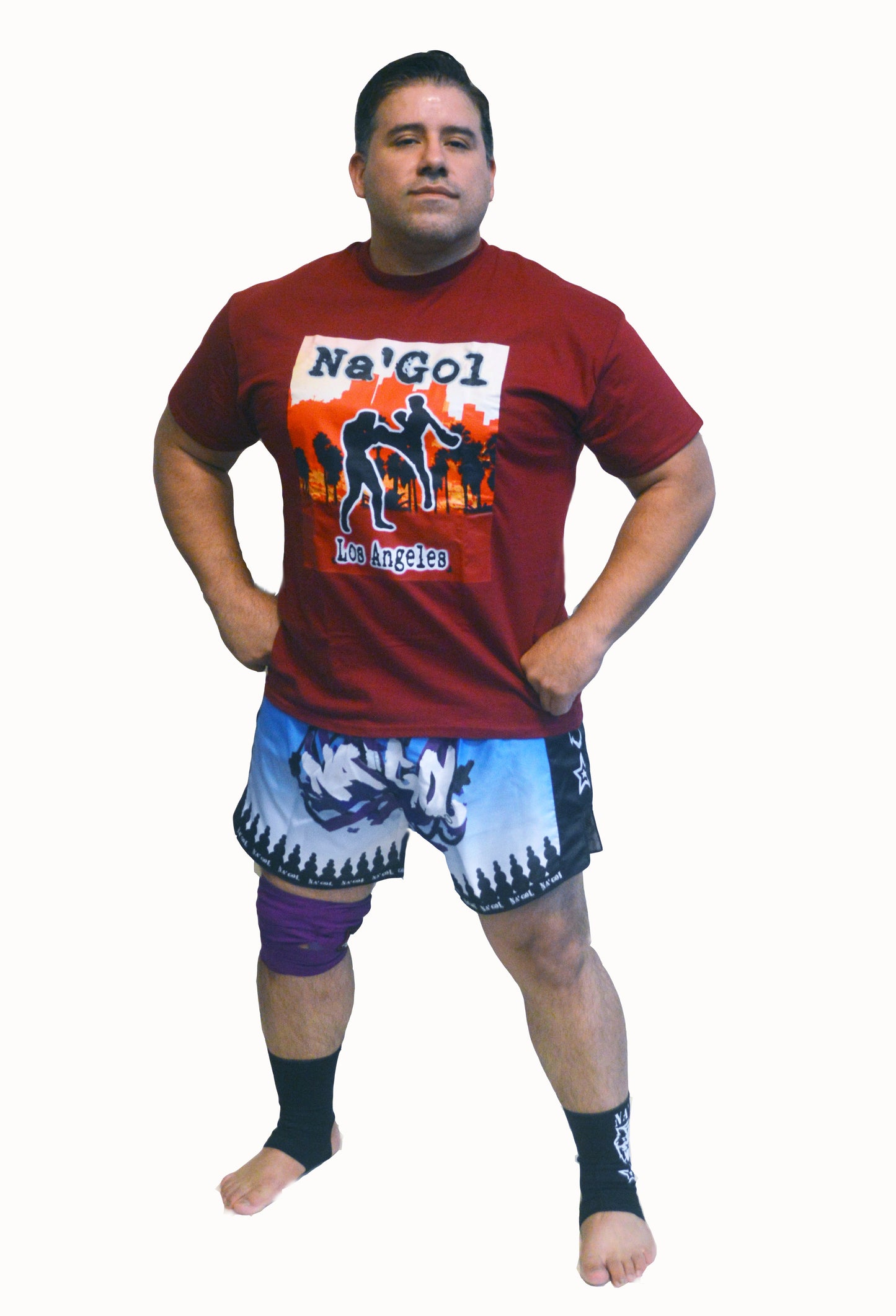 Man wearing a red t-shirt with 'Na'Gol Los Angeles' design and blue shorts on a white background