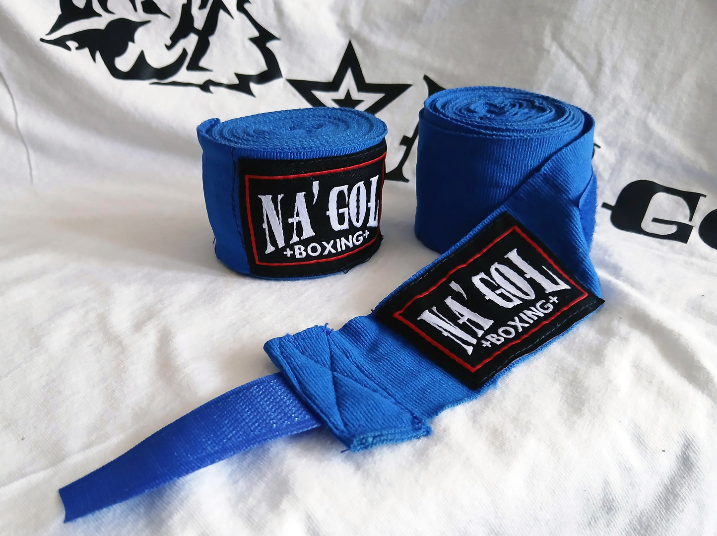 Blue boxing hand wraps with 'NA'GOL BOXING' branding on a white background